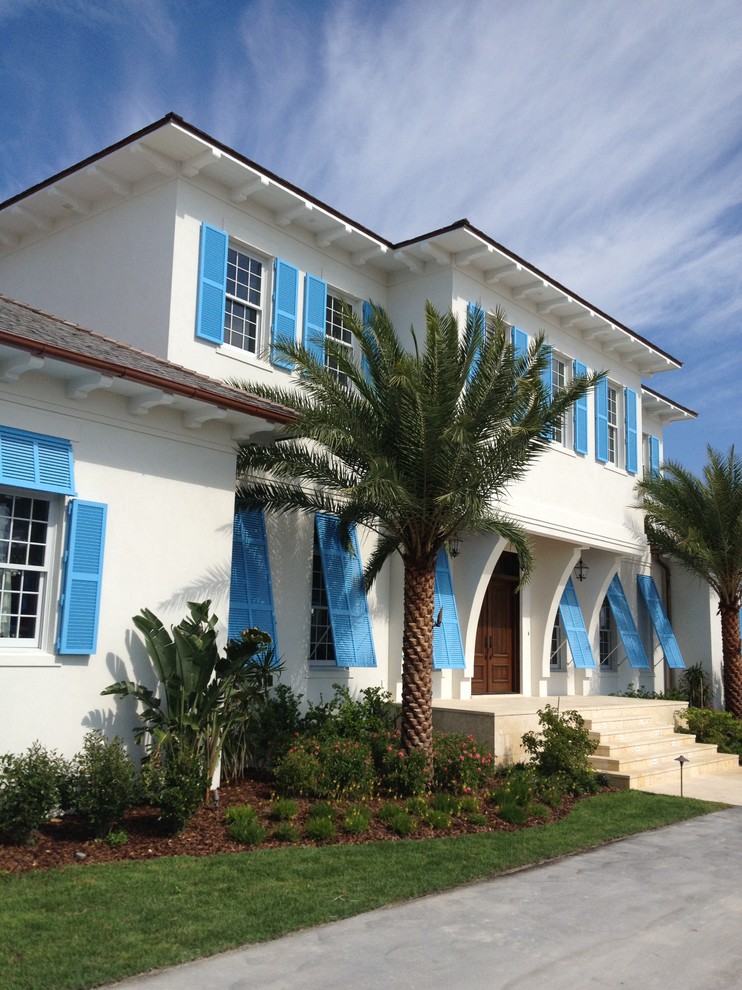 Design ideas for a large tropical two-storey stucco white exterior in Tampa.