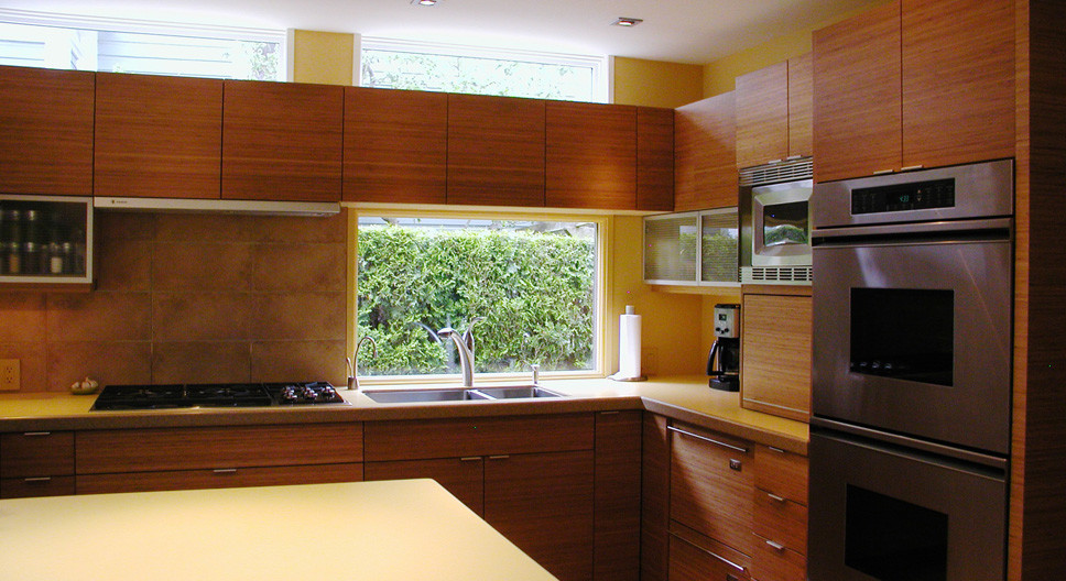 Design ideas for an asian l-shaped eat-in kitchen in Vancouver with an undermount sink, flat-panel cabinets, medium wood cabinets, quartz benchtops, grey splashback, porcelain splashback and stainless steel appliances.