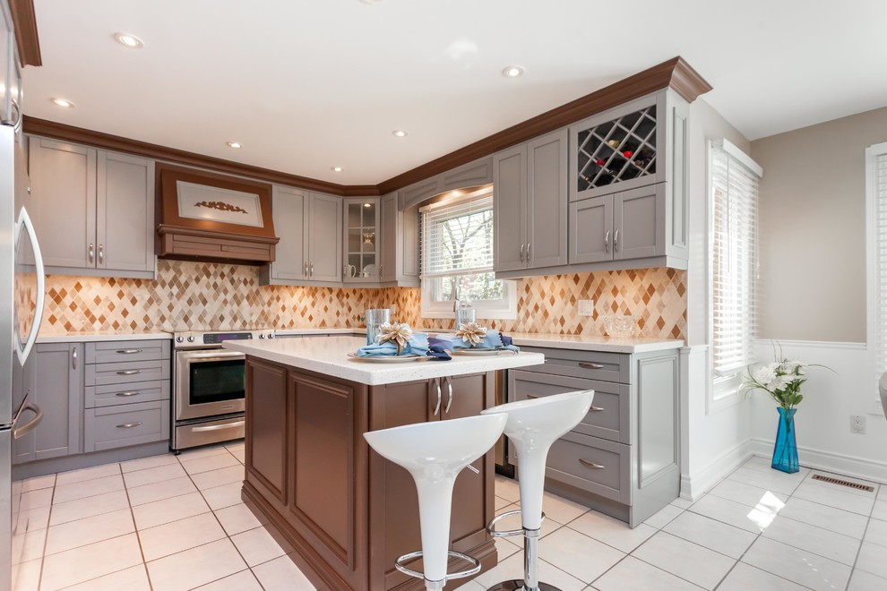 Inspiration for a large traditional u-shaped eat-in kitchen in Toronto with an undermount sink, shaker cabinets, grey cabinets, quartz benchtops, beige splashback, mosaic tile splashback, stainless steel appliances, ceramic floors, with island and beige floor.