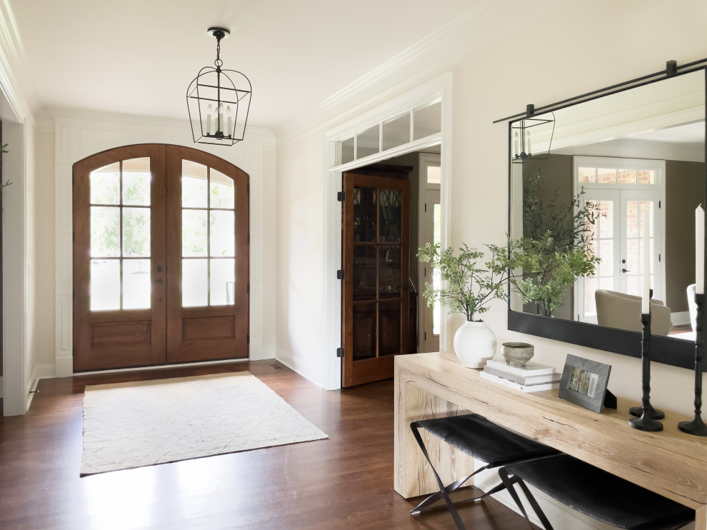 Photo of a large transitional foyer in Nashville with white walls, dark hardwood floors, a double front door, a dark wood front door and brown floor.