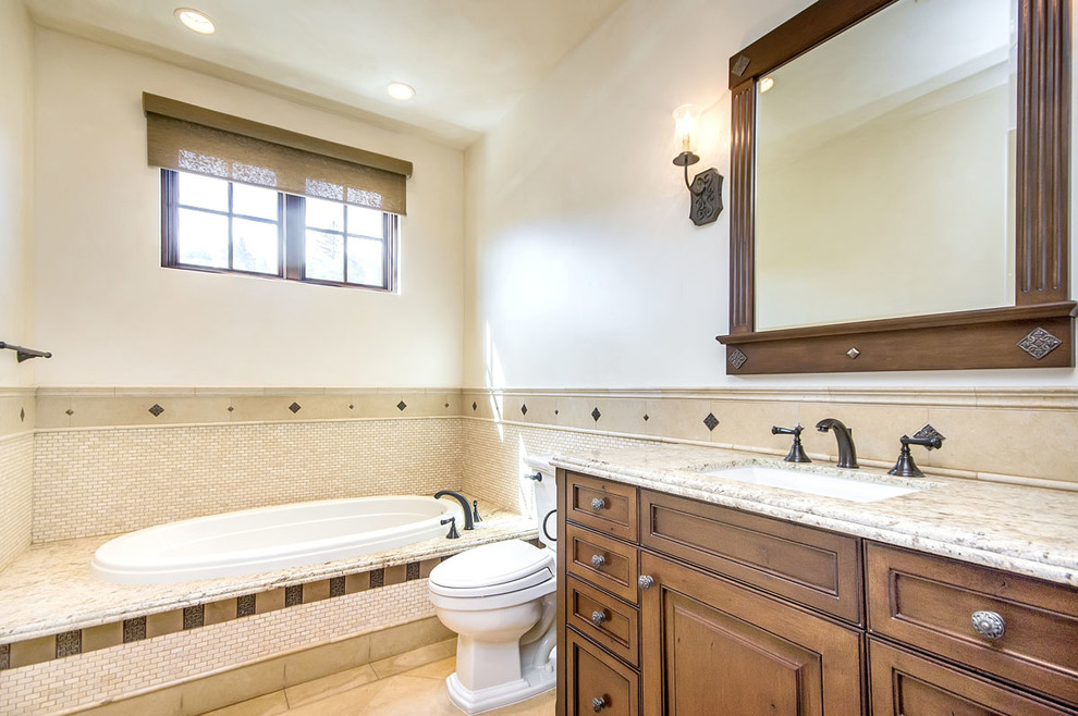 Design ideas for a large mediterranean kids bathroom in San Francisco with an undermount sink, beaded inset cabinets, medium wood cabinets, granite benchtops, a hot tub, a double shower, a one-piece toilet, beige tile, stone tile, beige walls and travertine floors.