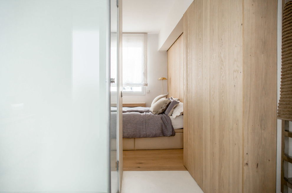 Mittelgroßes Mediterranes Hauptschlafzimmer mit hellem Holzboden, Kaminumrandung aus Holz, braunem Boden, brauner Wandfarbe und Eckkamin in Madrid