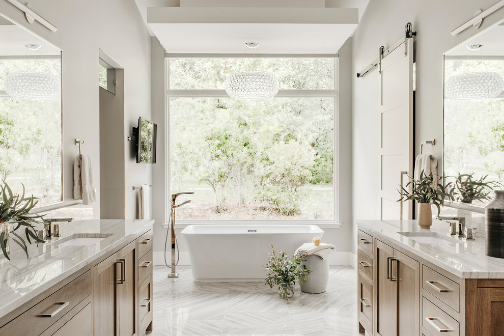 Inspiration for a large contemporary master bathroom in Austin with shaker cabinets, medium wood cabinets, a freestanding tub, a curbless shower, beige walls, porcelain floors, an undermount sink, quartzite benchtops, multi-coloured floor, a hinged shower door and white benchtops.