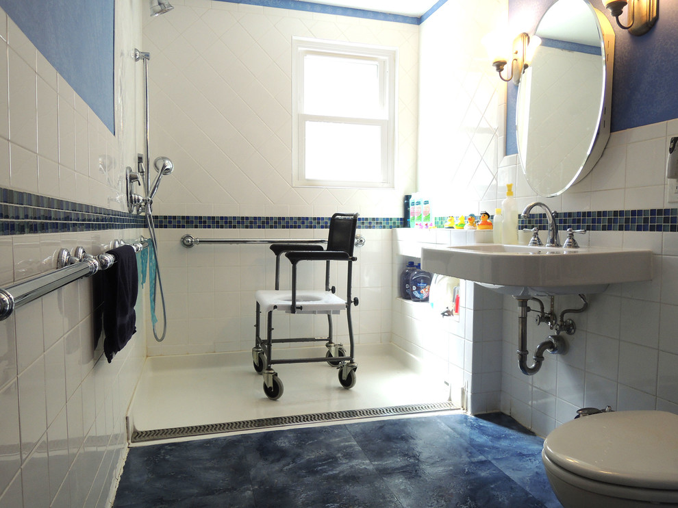 Photo of a mid-sized transitional bathroom in Baltimore with a wall-mount sink, a curbless shower, glass tile, blue walls, vinyl floors and blue tile.
