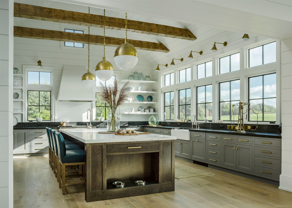 Inspiration for a country l-shaped kitchen in Burlington with a farmhouse sink, shaker cabinets, grey cabinets, light hardwood floors and with island.