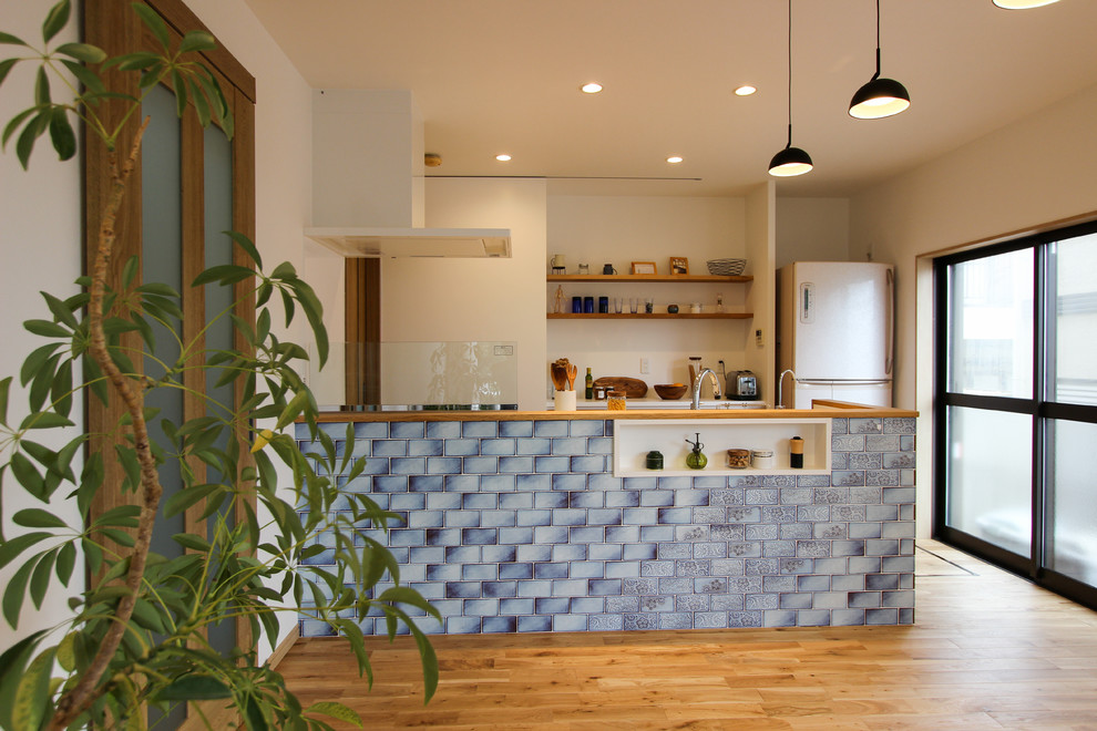 Photo of a scandinavian single-wall open plan kitchen in Other with medium hardwood floors, with island and brown floor.
