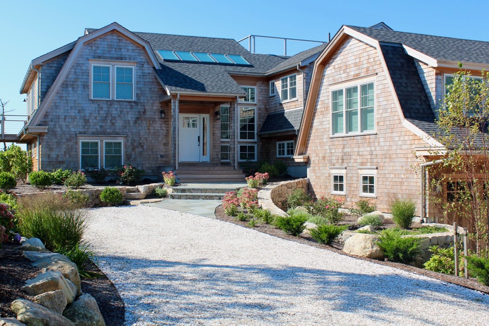 Inspiration for an expansive beach style full sun driveway for summer in Boston with a retaining wall and natural stone pavers.