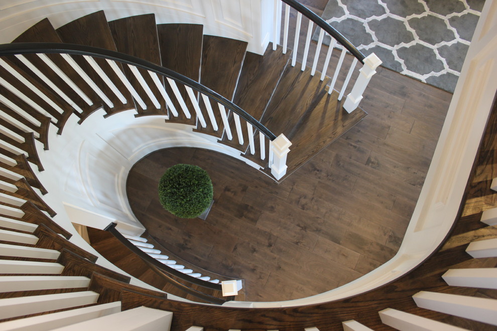 Expansive eclectic wood curved staircase in DC Metro with wood risers and wood railing.