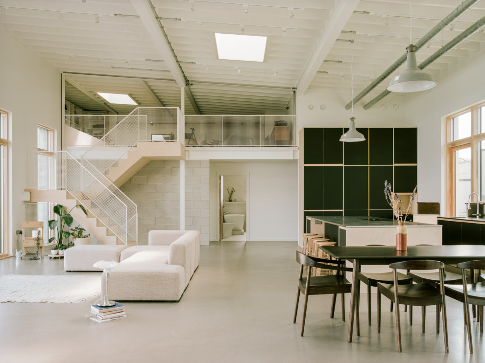 Exempel på ett stort modernt allrum med öppen planlösning, med en hemmabar, betonggolv, en öppen vedspis, grått golv och vita väggar