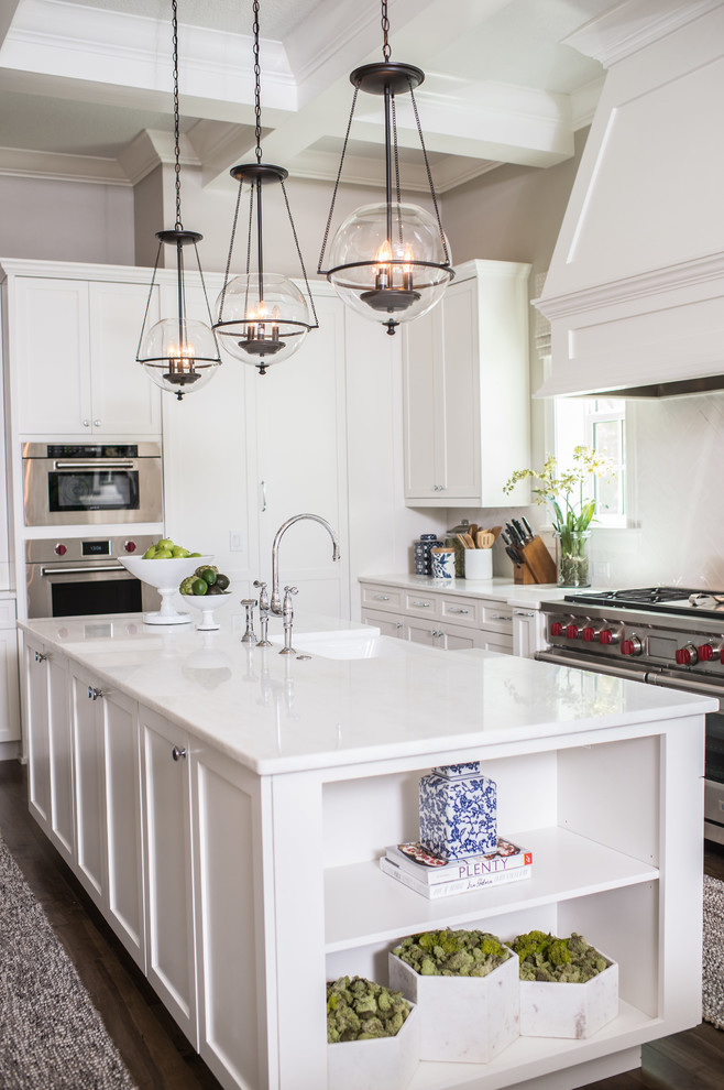 Design ideas for a mid-sized traditional l-shaped separate kitchen in Orlando with a farmhouse sink, shaker cabinets, white cabinets, solid surface benchtops, stainless steel appliances, dark hardwood floors, with island, brown floor and white benchtop.