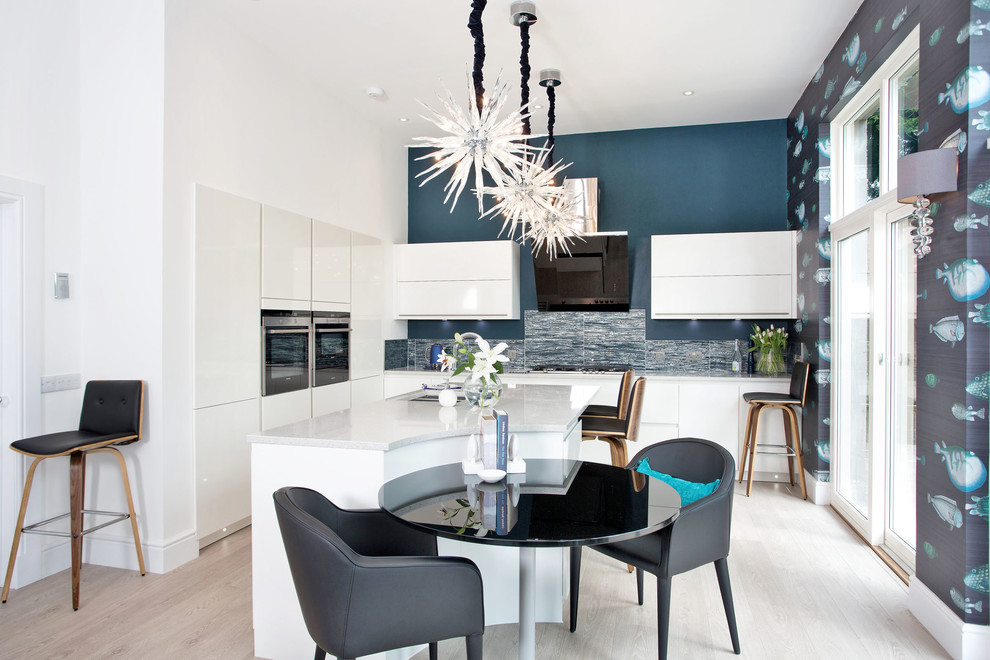 Mid-sized contemporary open plan kitchen in Other with an undermount sink, flat-panel cabinets, white cabinets, concrete benchtops, blue splashback, panelled appliances, light hardwood floors and with island.