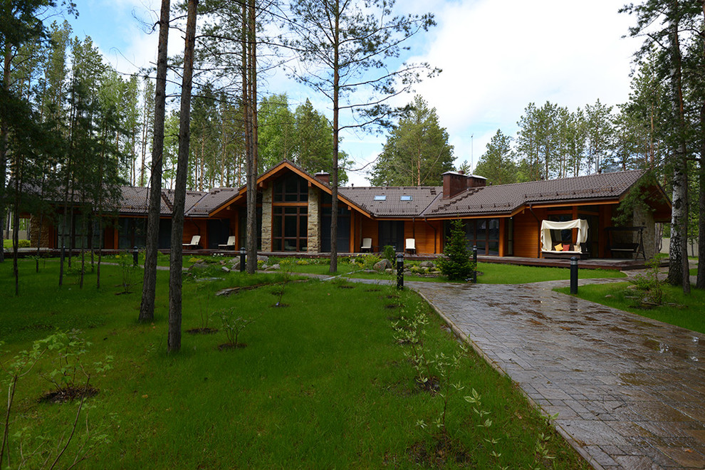 Large contemporary brown exterior in Novosibirsk with wood siding and a gable roof.