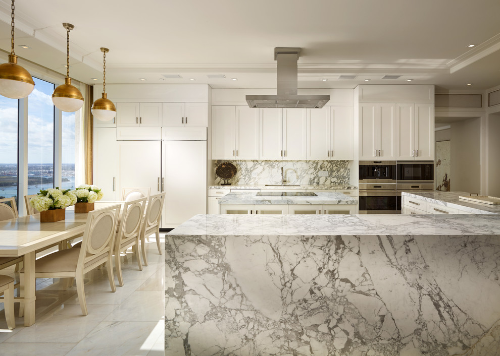 Inspiration for a large transitional eat-in kitchen in Miami with an undermount sink, recessed-panel cabinets, white cabinets, marble benchtops, white splashback, stone slab splashback, panelled appliances, marble floors and multiple islands.