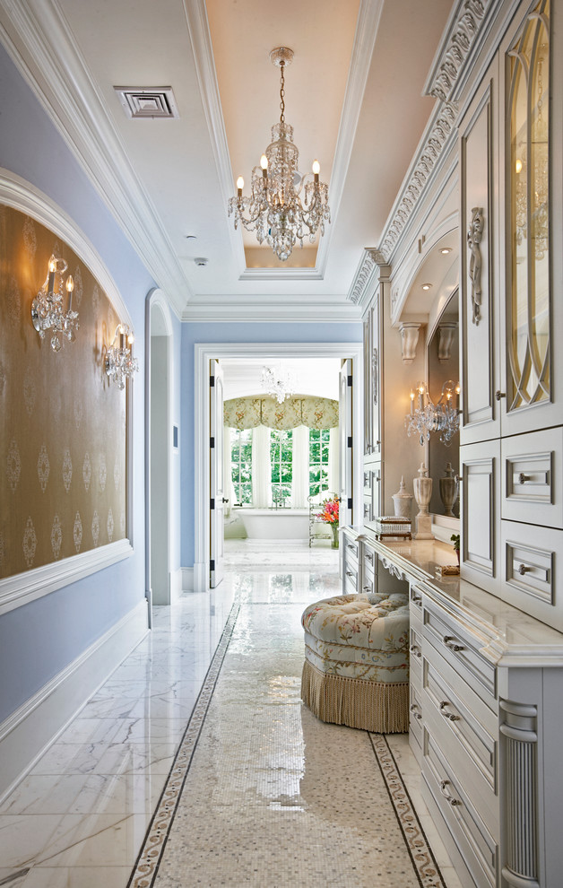 Photo of an expansive traditional master bathroom in Philadelphia with raised-panel cabinets, white cabinets, marble benchtops, a freestanding tub, blue walls and marble floors.