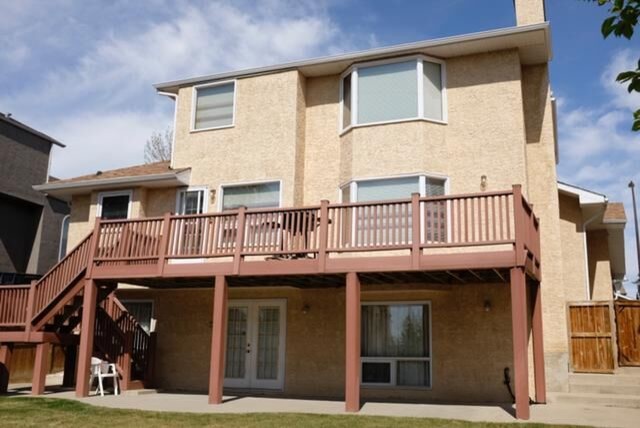 Mid-sized transitional beige three-story stucco gable roof photo in Calgary with a shingle roof
