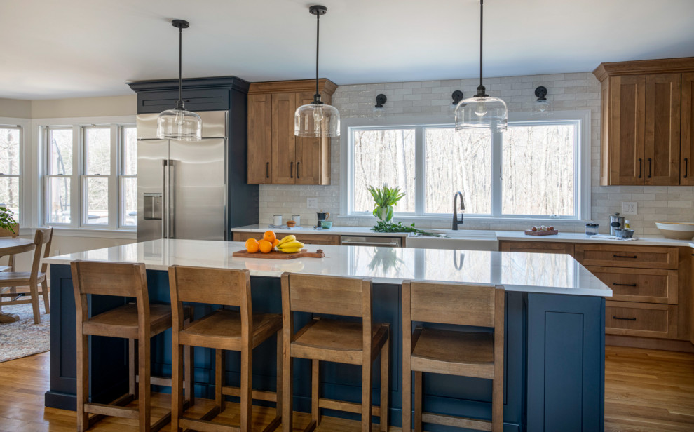 ボストンにある高級な広いトランジショナルスタイルのおしゃれなキッチン (ダブルシンク、シェーカースタイル扉のキャビネット、中間色木目調キャビネット、クオーツストーンカウンター、白いキッチンパネル、磁器タイルのキッチンパネル、シルバーの調理設備、無垢フローリング、青い床、白いキッチンカウンター) の写真