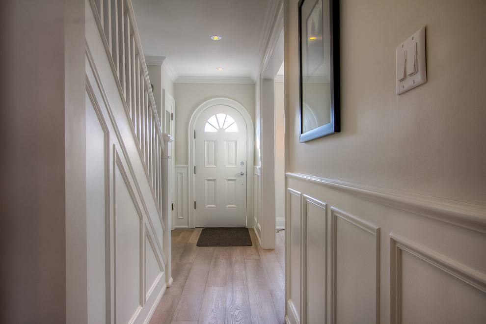 Photo of a mid-sized traditional hallway in Toronto with white walls and light hardwood floors.