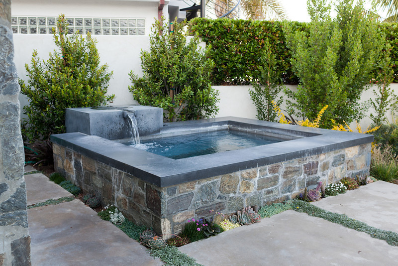 This is an example of a mid-sized midcentury backyard custom-shaped aboveground pool in Orange County with a hot tub and concrete slab.