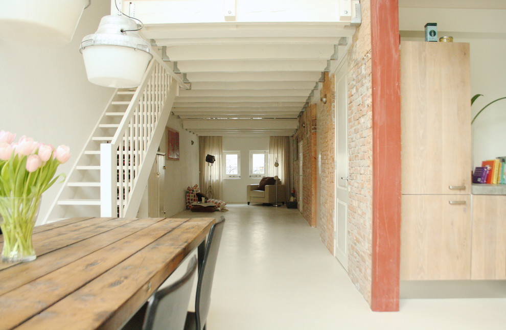 Photo of a small industrial living room in Amsterdam with white floor.