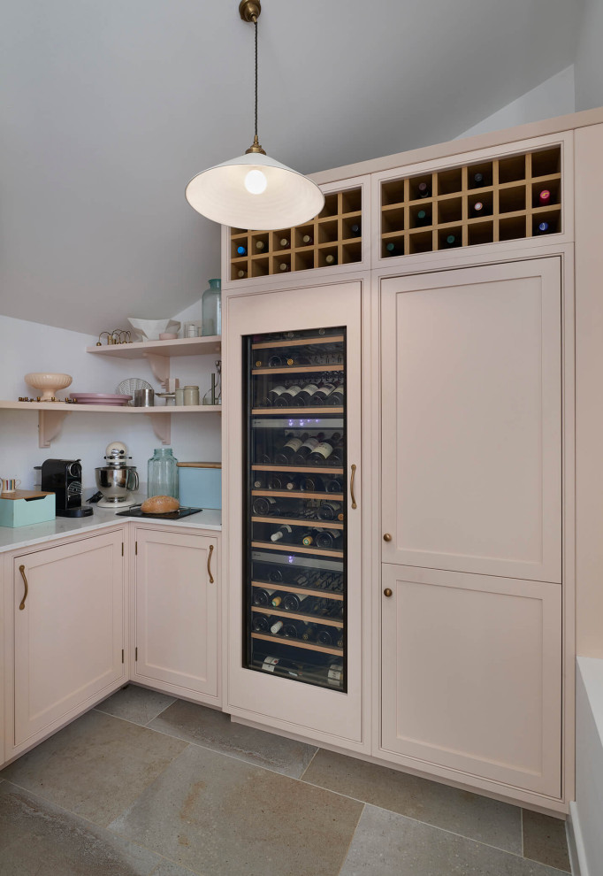 This is an example of a large country single-wall home bar in London with shaker cabinets, quartzite benchtops, pink splashback, ceramic floors, multi-coloured floor and grey benchtop.
