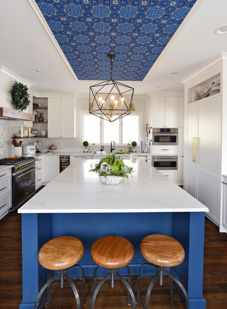 Example of a transitional dark wood floor and brown floor kitchen design in Cincinnati with shaker cabinets, white cabinets, gray backsplash, stainless steel appliances, an island and gray countertops