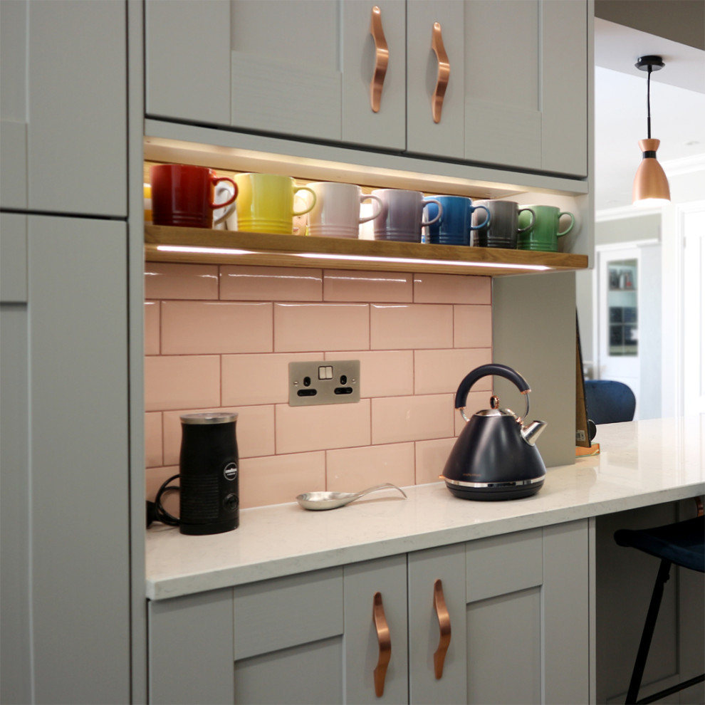 Photo of a mid-sized modern u-shaped eat-in kitchen in Hertfordshire with a farmhouse sink, shaker cabinets, grey cabinets, quartzite benchtops, pink splashback, subway tile splashback, panelled appliances, vinyl floors, a peninsula, brown floor and white benchtop.