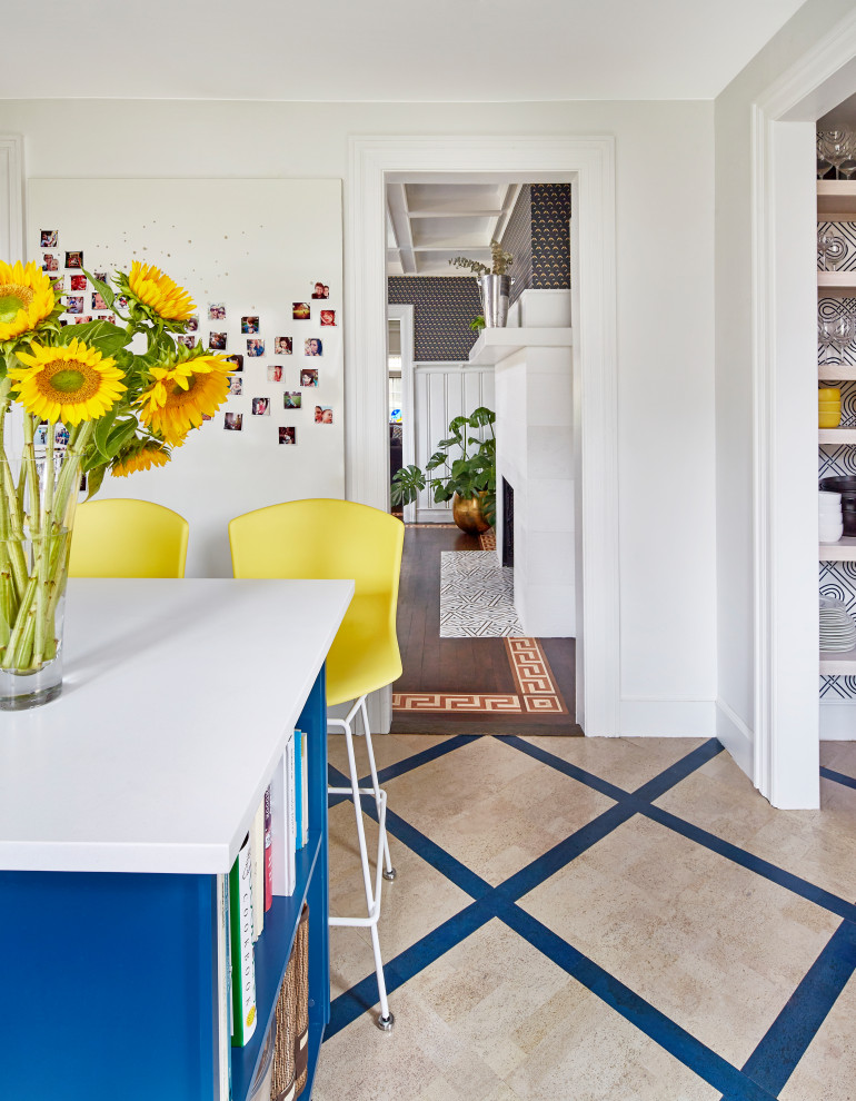 Inspiration för mellanstora eklektiska vitt kök, med luckor med upphöjd panel, blå skåp, bänkskiva i kvarts, vitt stänkskydd, rostfria vitvaror, korkgolv, en köksö och flerfärgat golv
