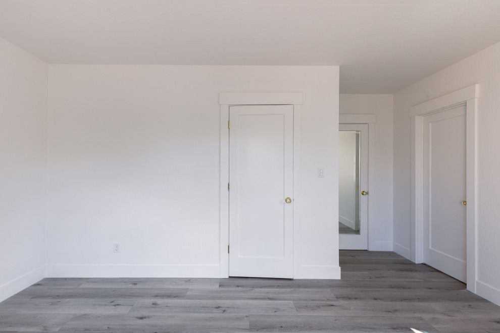 Inspiration for a mid-sized transitional master bedroom in Seattle with white walls, a standard fireplace, a tile fireplace surround, brown floor, brick walls and vinyl floors.