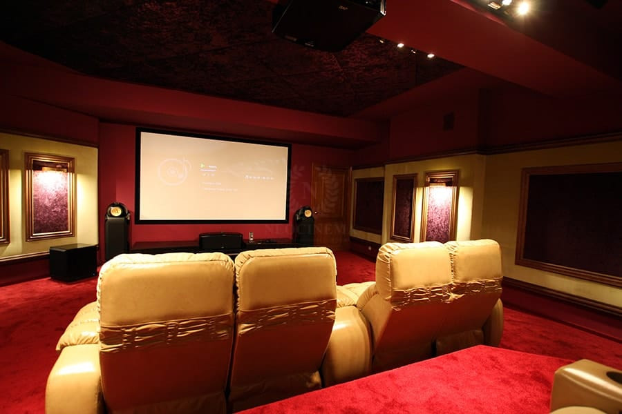 Foto de cine en casa cerrado con paredes rojas, moqueta, pantalla de proyección y suelo rojo