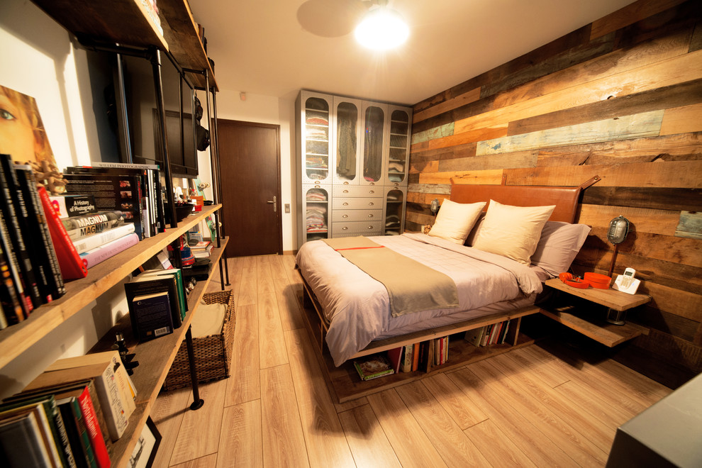 Mid-sized industrial master bedroom in Other with white walls and light hardwood floors.
