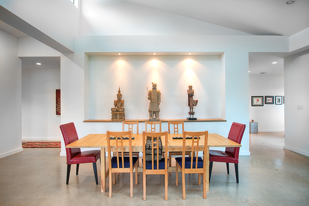Photo of an asian dining room in Austin with concrete floors.