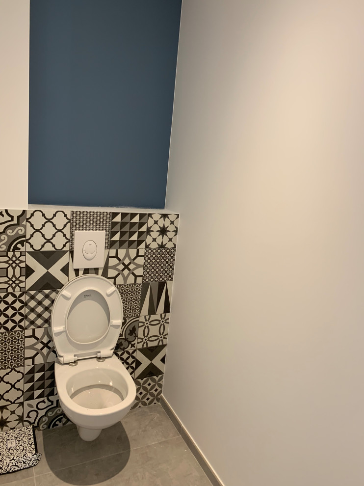 Imagen de aseo minimalista pequeño con sanitario de pared, baldosas y/o azulejos blancas y negros, baldosas y/o azulejos de cerámica, paredes azules, suelo de baldosas de cerámica y suelo gris