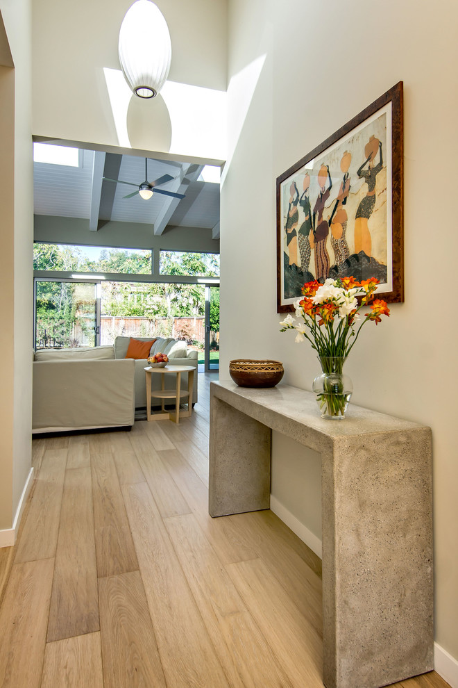 This is an example of a mid-sized midcentury entry hall in San Francisco with beige walls, light hardwood floors and beige floor.