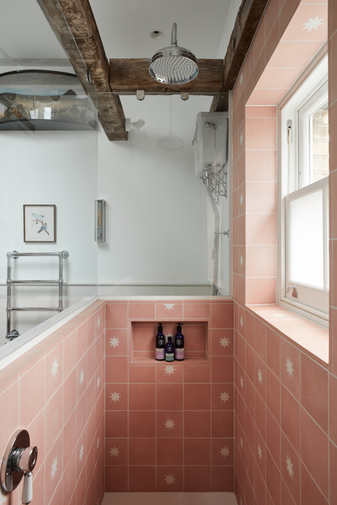 На фото: маленькая детская ванная комната в стиле фьюжн с фасадами с утопленной филенкой, бежевыми фасадами, отдельно стоящей ванной, открытым душем, инсталляцией, розовой плиткой, цементной плиткой, белыми стенами, деревянным полом, врезной раковиной, серым полом, душем с распашными дверями, белой столешницей, нишей, тумбой под одну раковину, напольной тумбой, балками на потолке и панелями на части стены для на участке и в саду