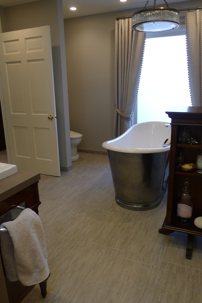 Freestanding bathtub - large transitional master gray tile and porcelain tile porcelain tile freestanding bathtub idea in Indianapolis with a drop-in sink, furniture-like cabinets, dark wood cabinets, solid surface countertops, a one-piece toilet and gray walls
