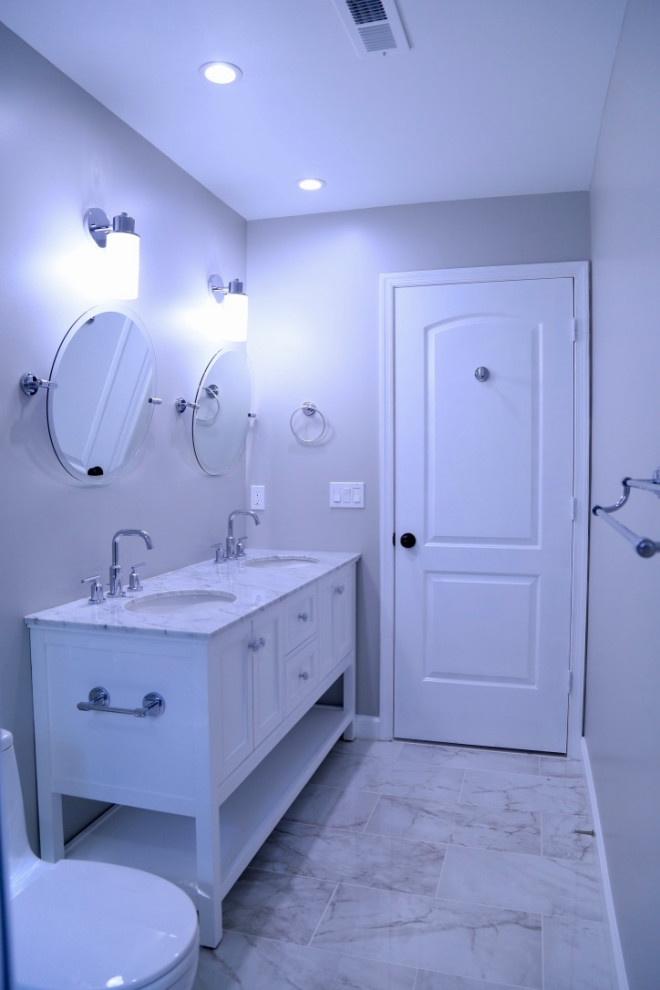 Mid-sized modern master bathroom in Houston with recessed-panel cabinets, white cabinets, an alcove shower, a one-piece toilet, multi-coloured tile, marble, grey walls, marble floors, an undermount sink, marble benchtops, multi-coloured floor, a sliding shower screen and white benchtops.