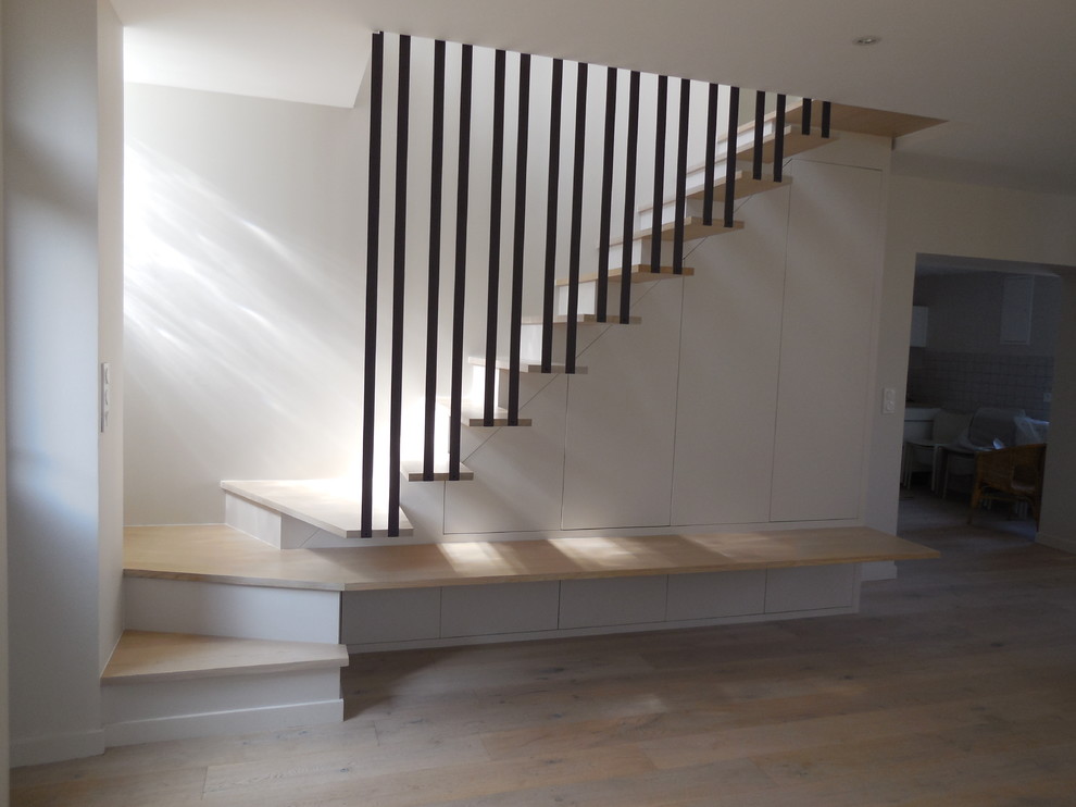 Idée de décoration pour un escalier peint design en L de taille moyenne avec des marches en bois.
