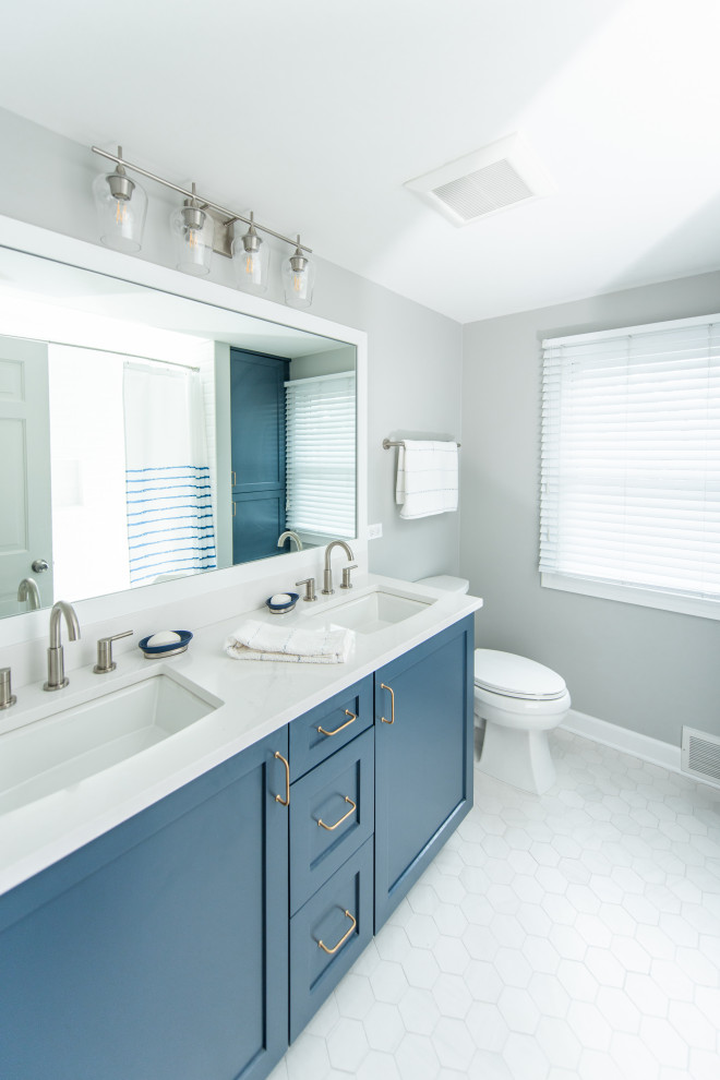 Aménagement d'une douche en alcôve classique avec un placard à porte shaker, des portes de placard bleues, une baignoire en alcôve, WC séparés, un carrelage blanc, des carreaux de céramique, un mur beige, un sol en carrelage de céramique, un lavabo encastré, un plan de toilette en quartz modifié, un sol gris, une cabine de douche avec un rideau, un plan de toilette blanc, une niche, meuble double vasque et meuble-lavabo encastré.