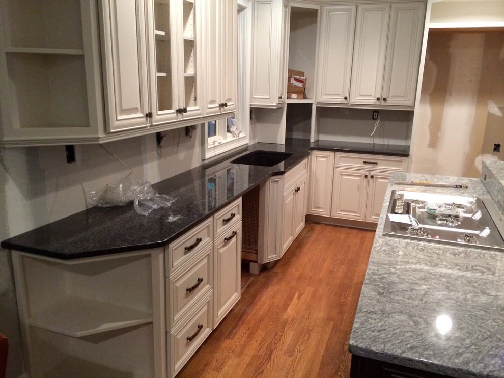 Eat-in kitchen - mid-sized transitional l-shaped eat-in kitchen idea in Atlanta with raised-panel cabinets, white cabinets, granite countertops and an island