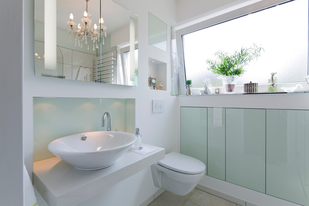 Inspiration for a mid-sized contemporary master bathroom in Hamburg with flat-panel cabinets, green cabinets, a drop-in tub, a curbless shower, a two-piece toilet, green tile, white walls, ceramic floors, a vessel sink and limestone benchtops.