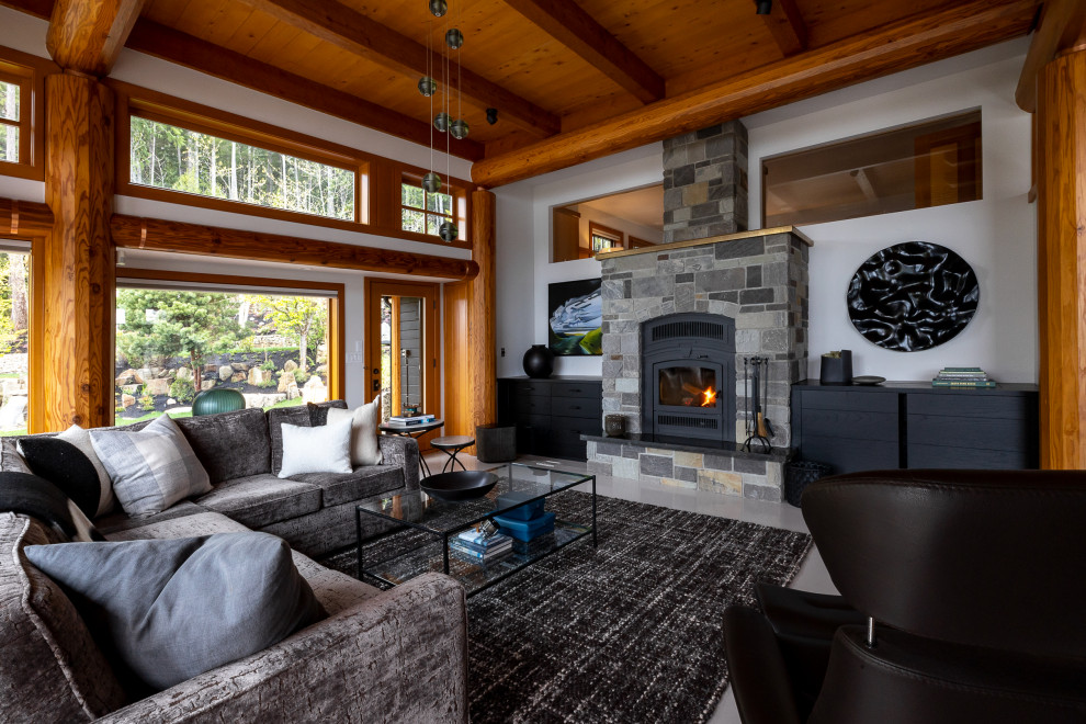 Design ideas for a large contemporary open plan living room in Vancouver with grey walls, carpet, a wood burning stove, a stone fireplace surround, a concealed tv, grey floors, exposed beams and wood walls.