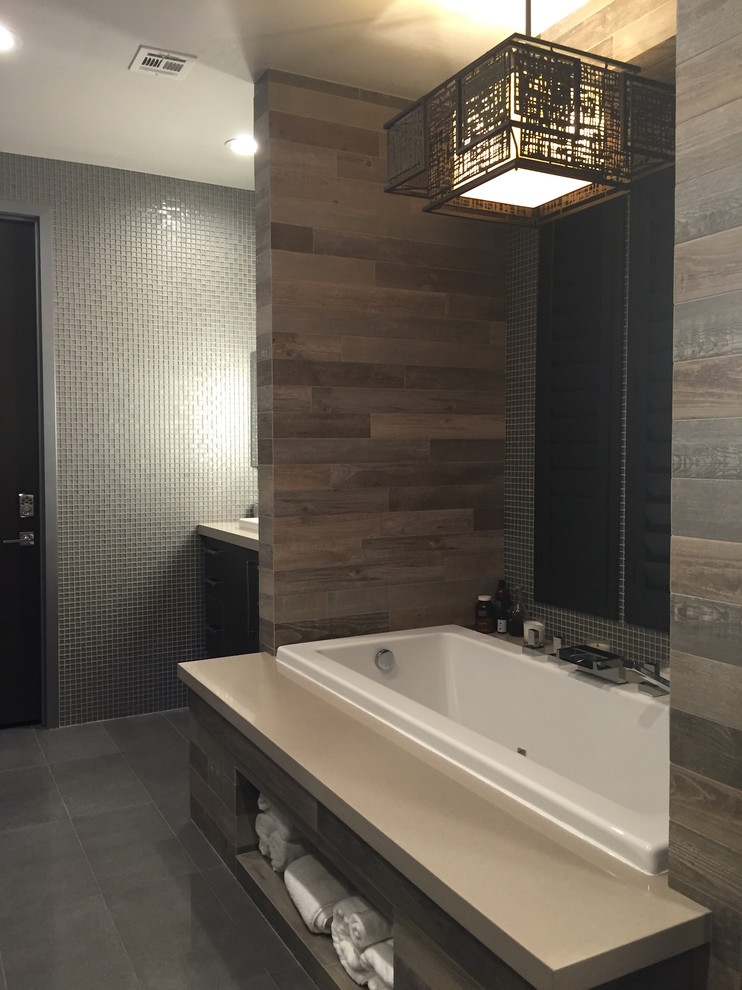 Design ideas for a mid-sized asian master bathroom in Las Vegas with a drop-in sink, flat-panel cabinets, dark wood cabinets, quartzite benchtops, a drop-in tub, multi-coloured tile, porcelain tile, grey walls and porcelain floors.
