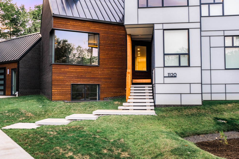 This is an example of a medium sized and brown two floor detached house in DC Metro with wood cladding, a metal roof, a grey roof and shiplap cladding.
