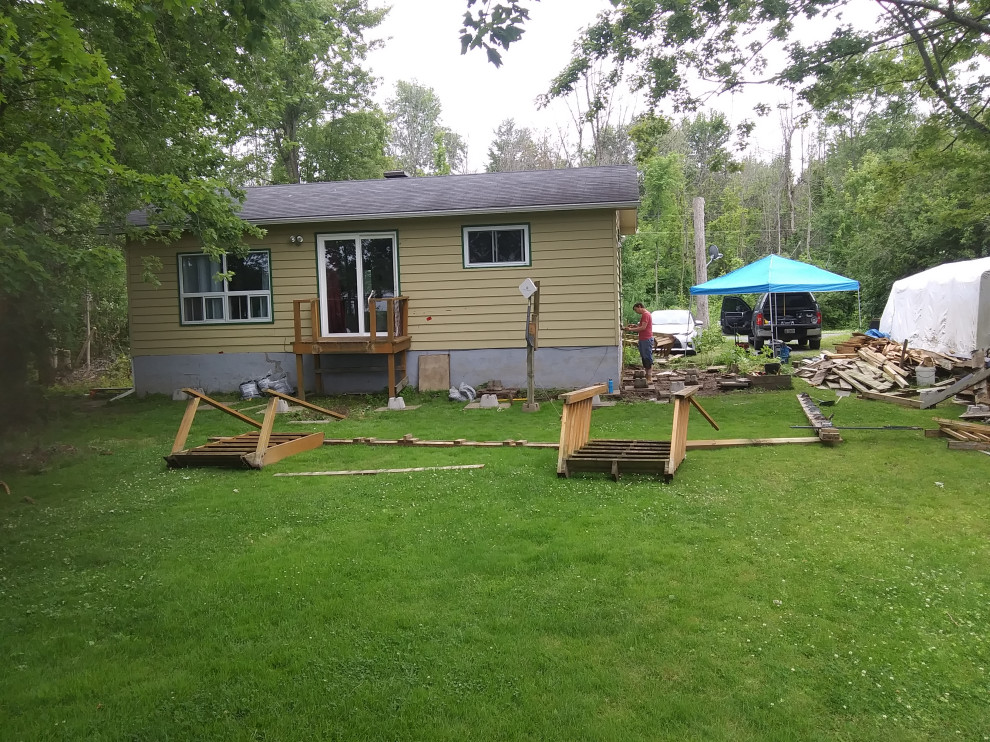 Example of a large transitional backyard wood railing deck design in Ottawa