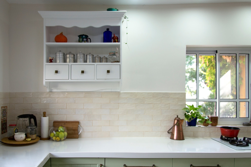 This is an example of a mid-sized mediterranean u-shaped eat-in kitchen in Tel Aviv with a single-bowl sink, shaker cabinets, green cabinets, quartz benchtops, beige splashback, ceramic splashback, ceramic floors, no island, grey floor and white benchtop.