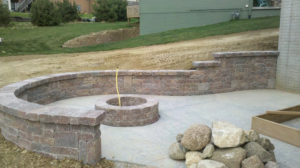 Inspiration for a mid-sized traditional backyard garden in Omaha with a retaining wall and concrete pavers.