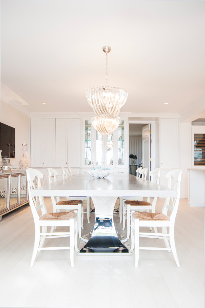 This is an example of a beach style open plan dining in New York with beige walls and light hardwood floors.