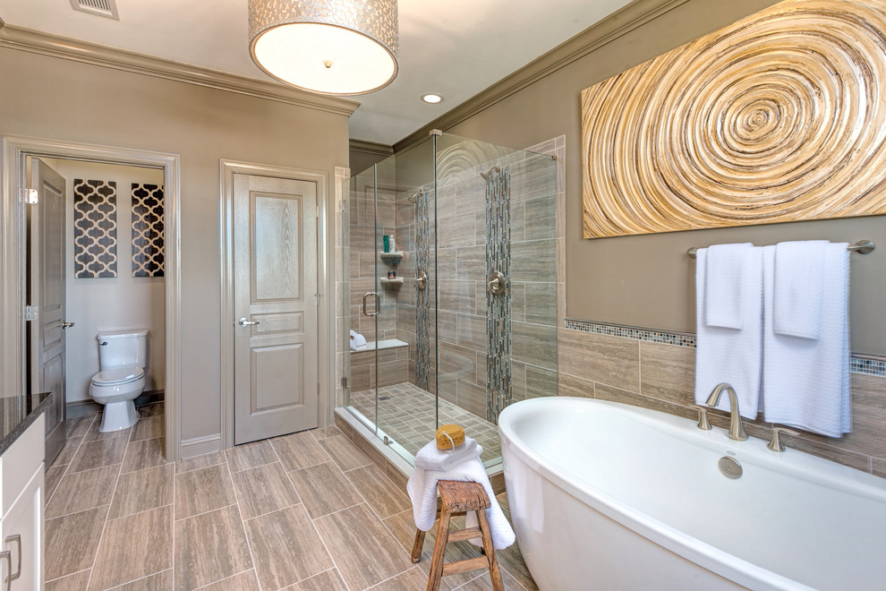 Design ideas for a transitional master bathroom in Atlanta with white cabinets, a freestanding tub, a corner shower, brown tile, brown walls, a hinged shower door and an enclosed toilet.