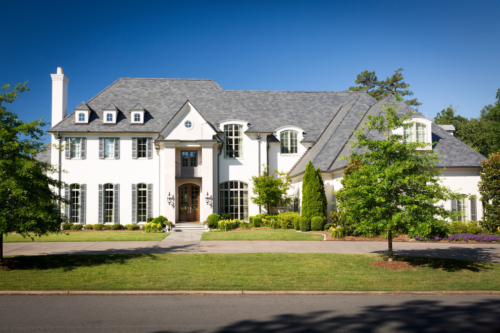 This is an example of a traditional two-storey white house exterior in Little Rock with a hip roof and a shingle roof.