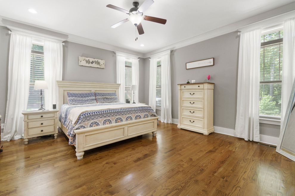 Inspiration for a large country master bedroom in Atlanta with grey walls and medium hardwood floors.